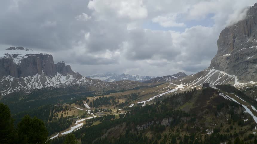 Drone view of a mountain landscape with trees in the valleys and snow on the mountain ridges