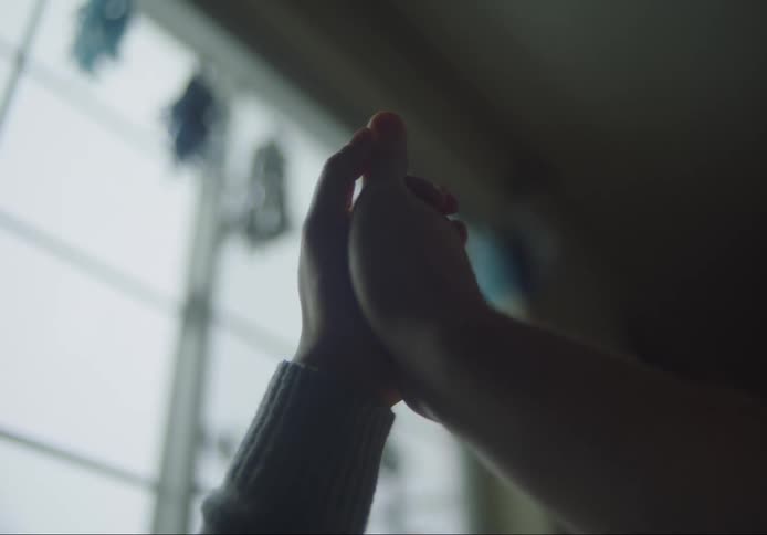 Hands thumb wrestle near window