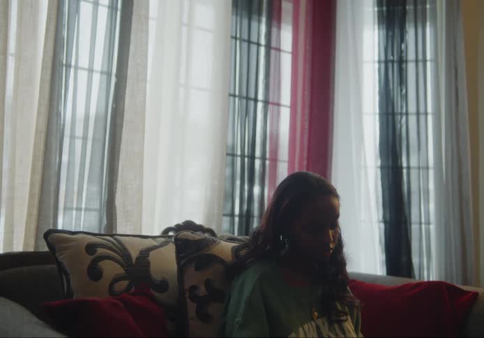 Teenage girl sitting on the sofa with a neutral expression