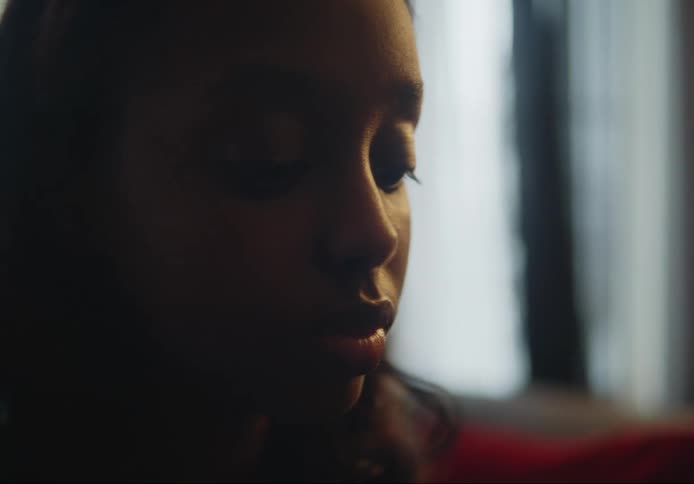 Portrait of a young black woman looking downward then looking forward with a joyful expression