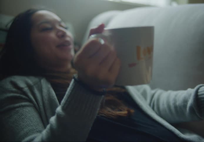A woman has a drink while her man rubs her leg