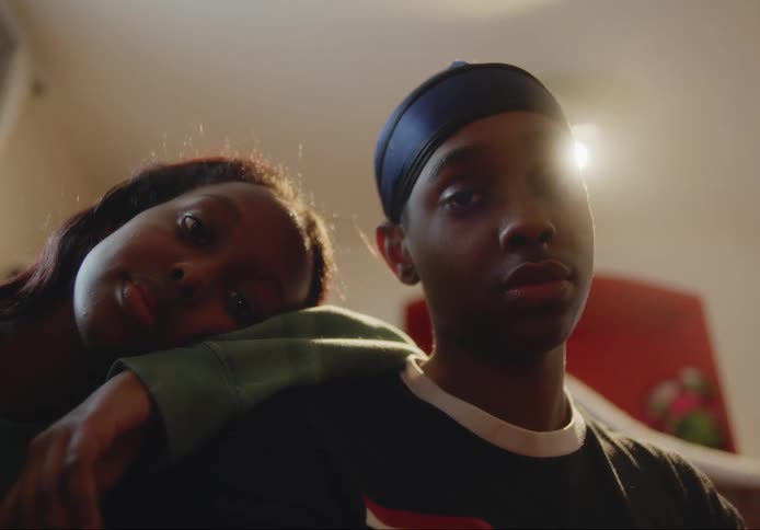 Adolescent boy and girl staring directly at the camera in an indoor setting with neutral facial expressions