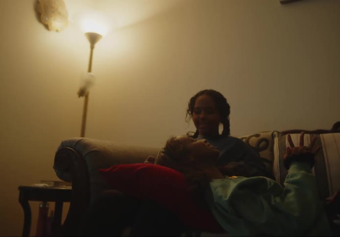 Teenage girl lying on the lap of another girl both conversing and smiling