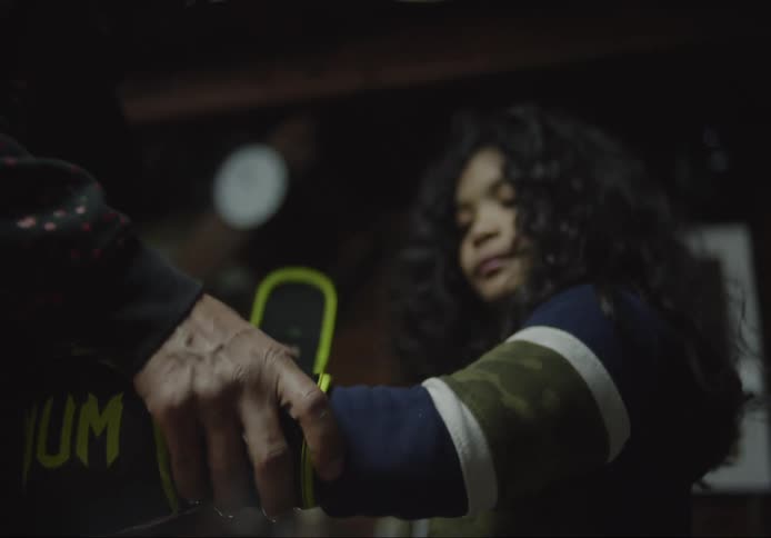 Man putting boxing gloves on a little girl indoors
