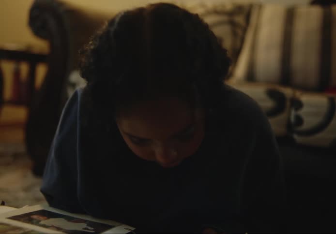 Girl sitting on the floor looking at a photo album