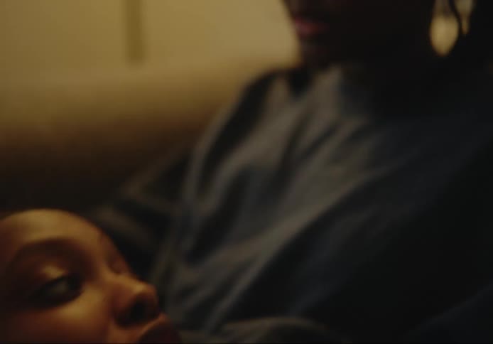 A young woman speaks while resting her head on another young womans lap