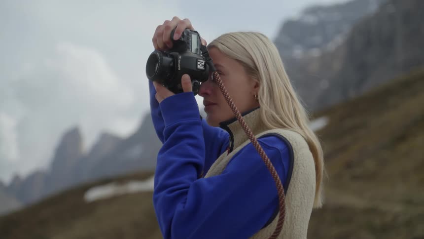 A young woman photographs the landscape during the winter