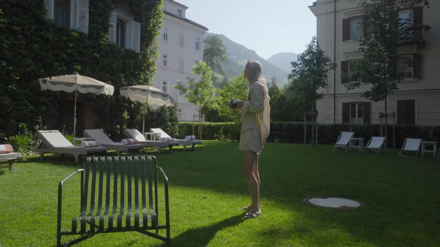 A woman photographs the garden on a sunny day