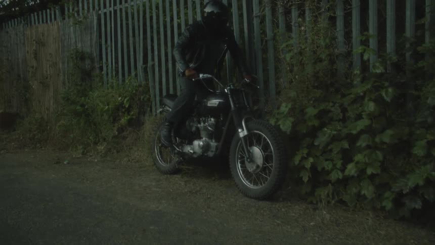 Man sprinting quickly to his motorcycle hopping on it and attempting to start the engine