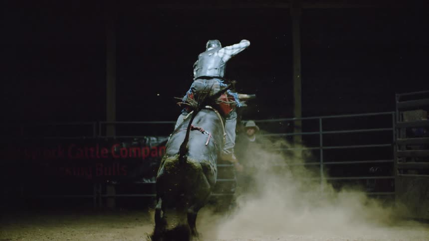 A man is riding a bull