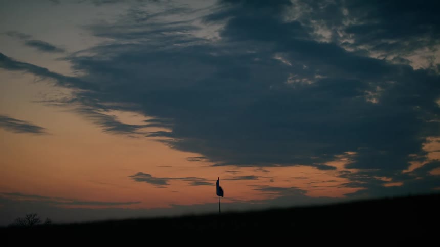 Flag waves on pole at dusk