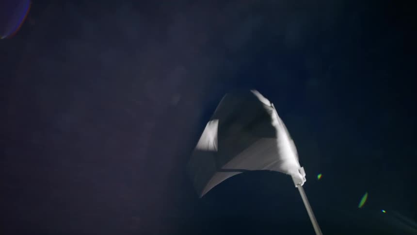 Closeup of a small flag moving in the wind during the night