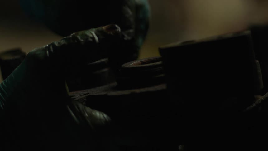Human hands with gloves covered in grease cleaning iron equipment