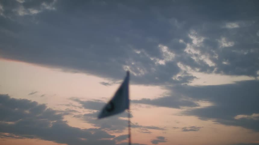 Small flag moving in the wind at dawn