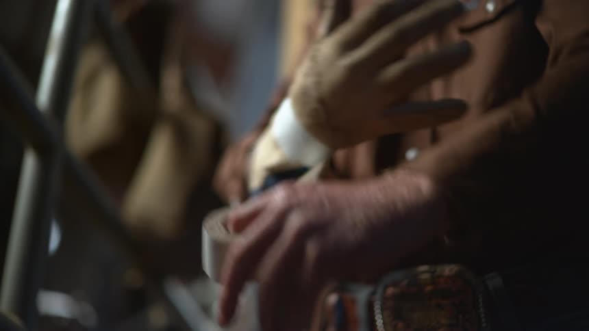 A man tapes a glove on his hand