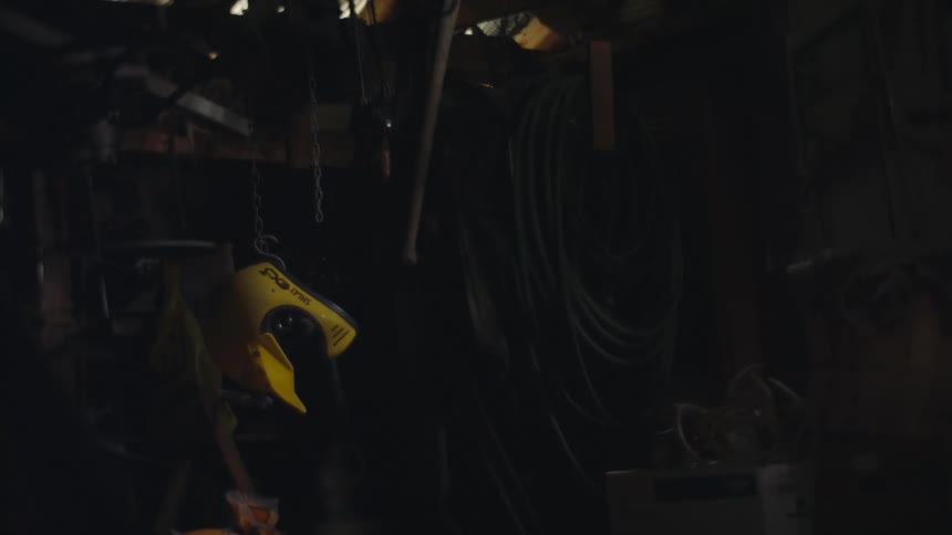 A yellow object hanging from an iron chain is swinging