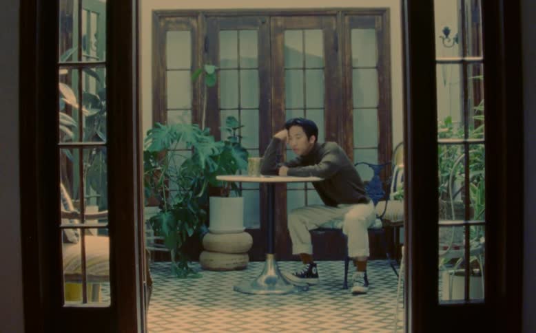 A man is sitting at a table sleeping with his head resting on his hand