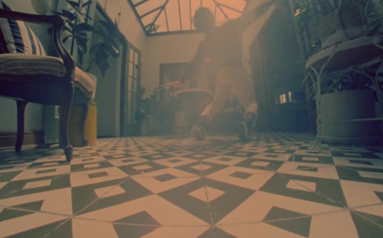 Asian man dancing indoors in a room at a house during day time