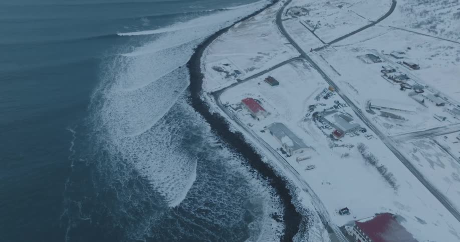 Aerial view of a small area with snowcovered residences by the seaside
