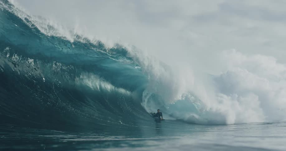 Bodyboarder riding large barrel wave