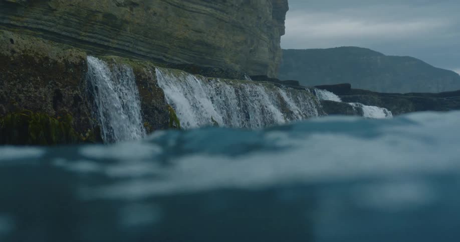 Sea water running down a rock formation into the ocean