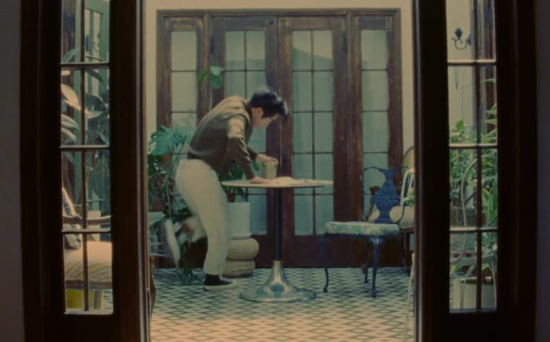 Man dances in room stopping briefly to mime taking a drink