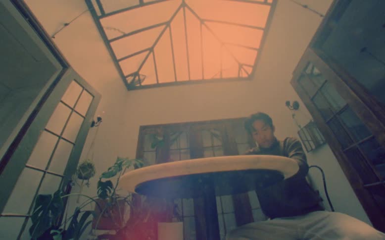Man sitting and taking a sip from a cup then suddenly waking up and his leg starts to swing