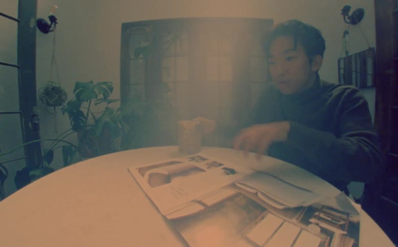 Man dances while miming drinking and reading a magazine in room