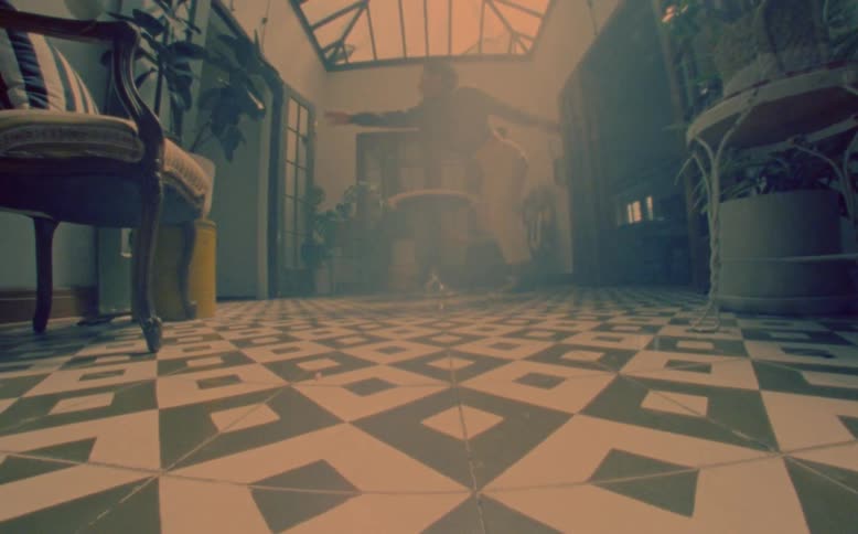Man dancing on the floor and standing up inside an indoor space