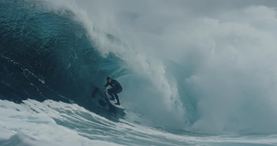 Man riding inside a wave while surfing in rough waters