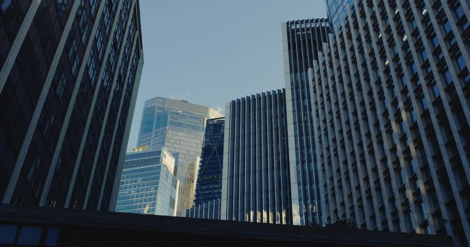 Downtown buildings and skyscrapers stand close together under a blue sky