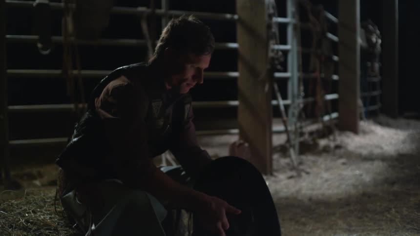 Cowboy contemplating something while spinning his hat before he puts it on and  rises up to walk away