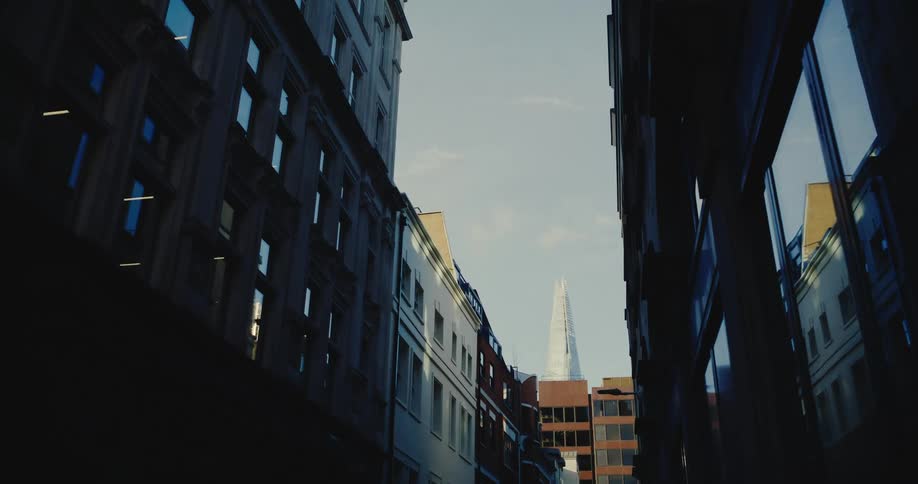 Skyscraper towers over building at end of street