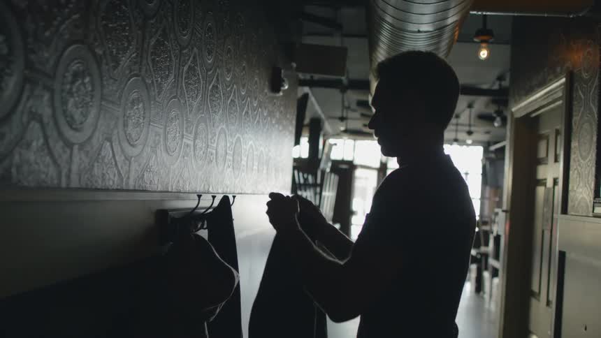 Man walks into a business and hangs up his coat