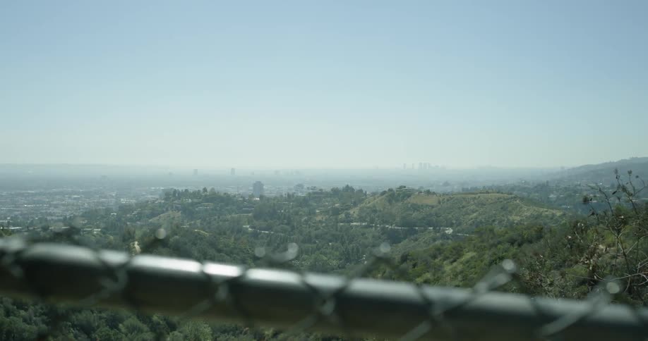 Beyond the fence is a valley covered with grass below