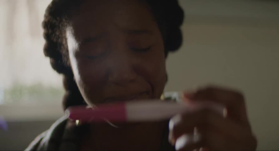 A woman crying with happiness with a pregnancy test in her hands