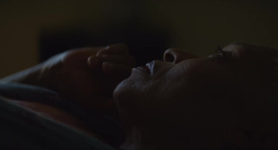 Worried and tense black woman lying down in a bed indoors during night time