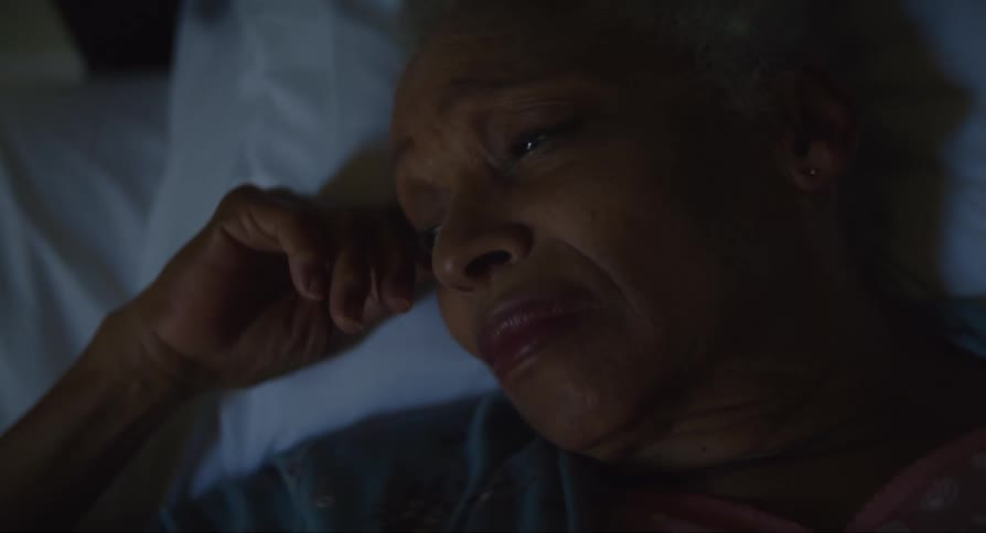 Woman lies head on pillow looking sad and distressed