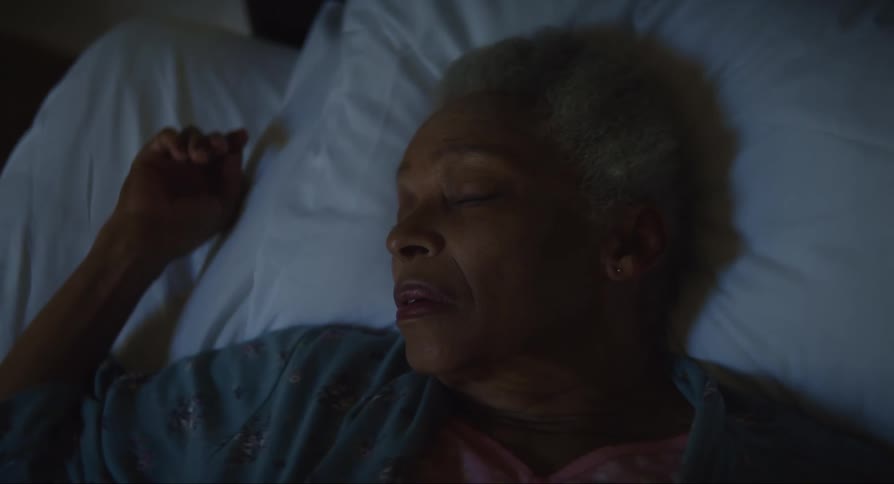 Elderly woman lying in bed and observing