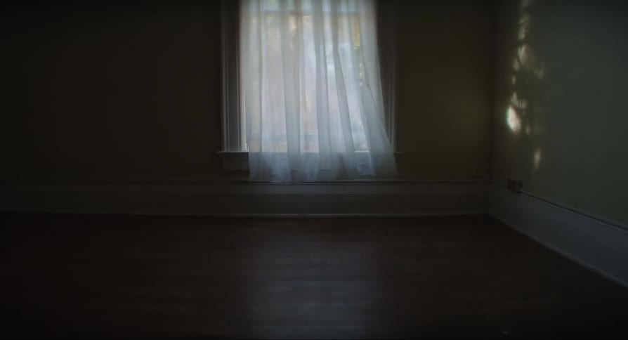 A curtain waving with the wind in an empty room