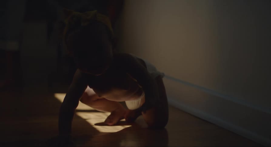 Parent reaches down toward baby crawling across floor