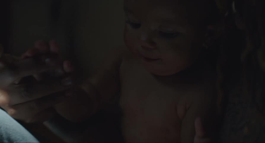 Mother sitting and using her hands to play with her baby