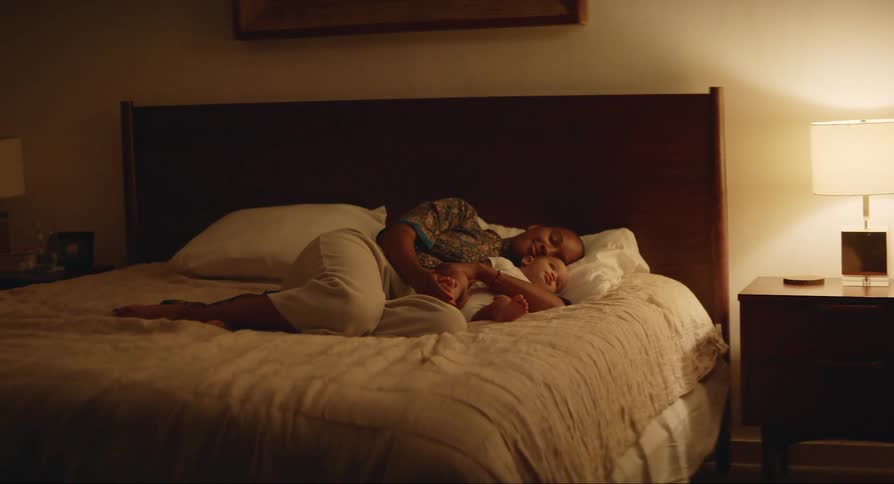 Father lying on the bed with his baby son