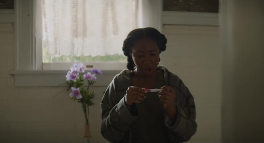 Woman looking at her pregnancy test and appearing surprised