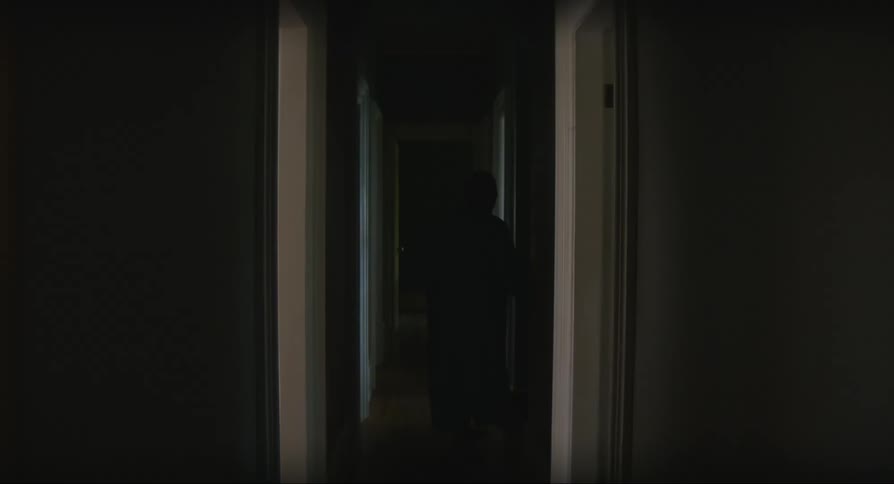 Elderly woman leaving the room in a robe and walking to another room using a walker