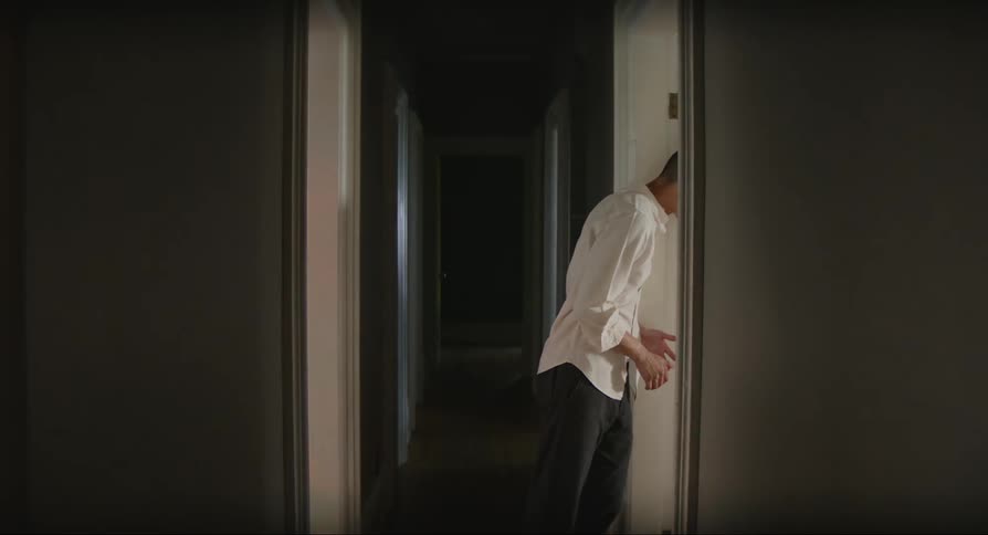 Man in a hallway of a house observing