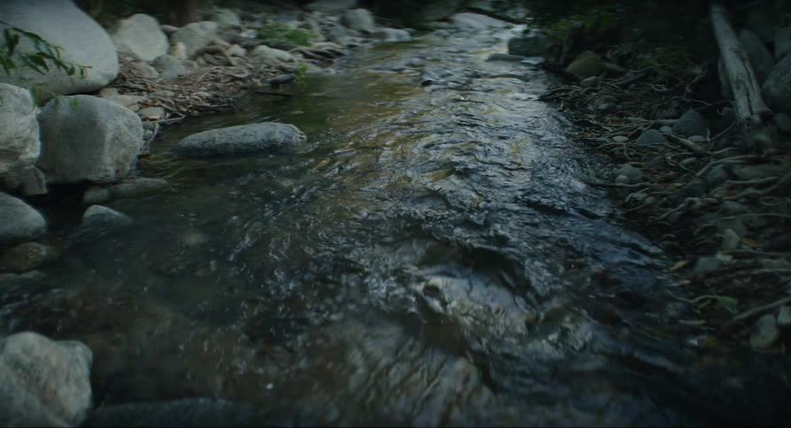 A small stream with rocks on a cloudy day