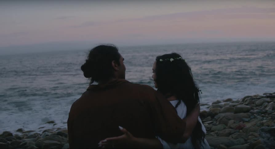 A man and a woman embracing talking in front of the sea