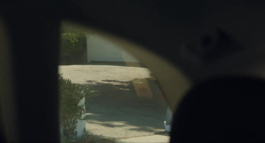 A woman watches a car drive from her home