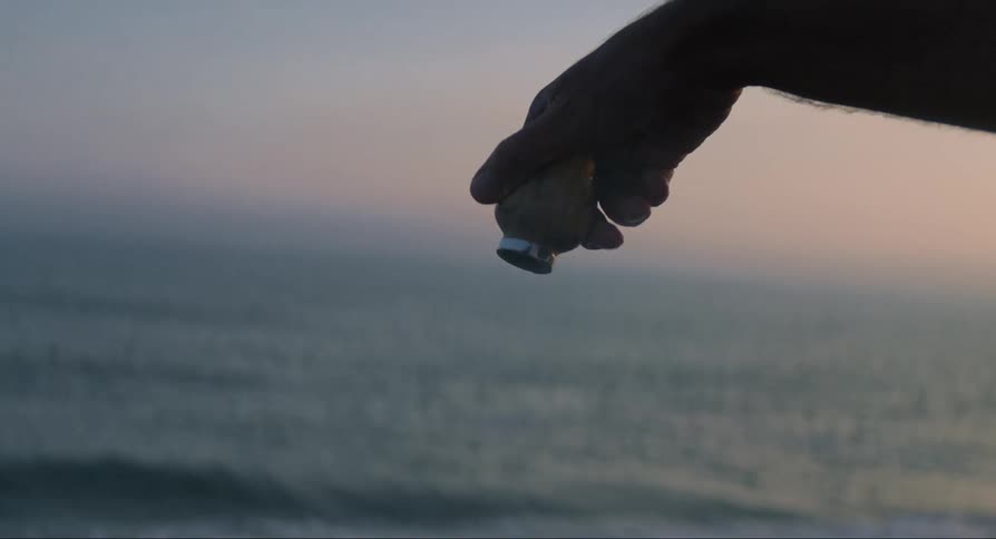 A person pours ashes from an urn into the ocean